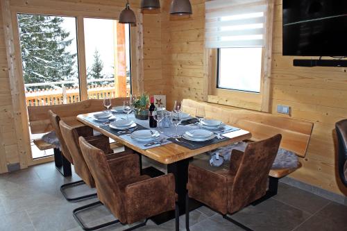 a dining room with a wooden table and chairs at Sonnenblickhütte in Klippitztorl