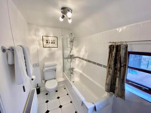 a bathroom with a tub and a toilet and a sink at Catesby Barn Farm B&B in Daventry