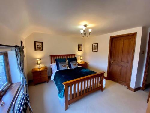 a bedroom with a bed with a blue comforter at Catesby Barn Farm B&B in Daventry