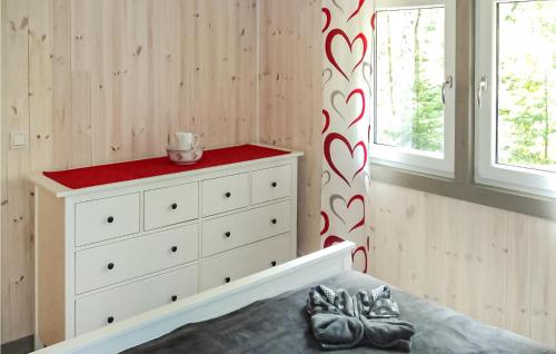 a bedroom with a white dresser with a red top at 2 Bedroom Cozy Home In Järnforsen in Järnforsen