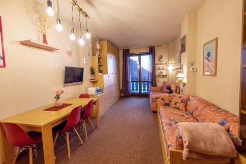 uma sala de estar com um sofá e uma mesa em Happy Guest Apartments - Pink Mountain Presolana em Castione della Presolana