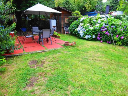 a yard with a table and chairs and flowers at Guest House MiLinco - Ala Maison in Pucón