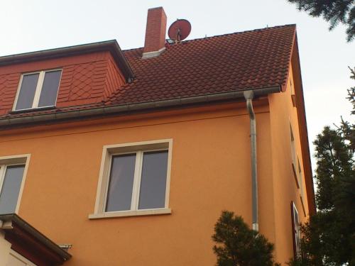 a orange house with two windows and a roof at Ferienwohnung Dresden West in Dresden