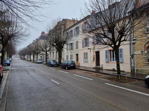 an empty street with cars parked on the side of the road at Appartement 2/4 pers Le Cosy in Lons-le-Saunier