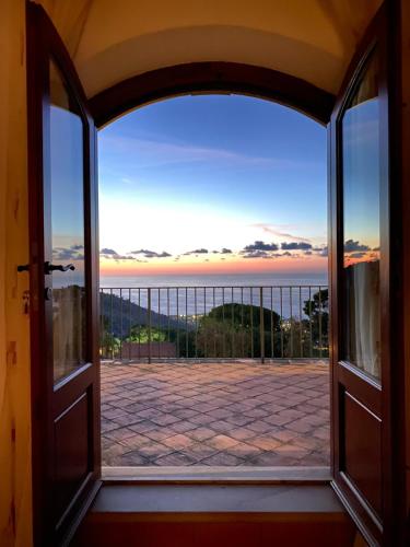 an open door with a view of the ocean at B&B Le Ginestre in Cefalù