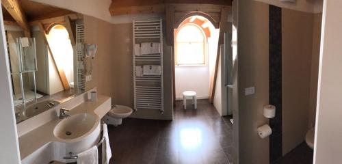 a bathroom with a sink and a toilet and a window at Park Hotel Pineta Boutique Hotel in Caorle