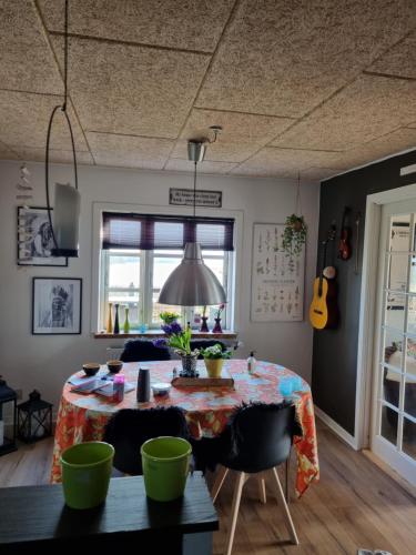 a dining room with a table and a guitar at Marsvinslund bed and breakfast in Viborg