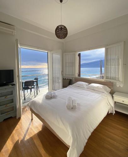 a bedroom with a large bed with a view of the ocean at Thassa Beach Apartment No4 in Leonidion
