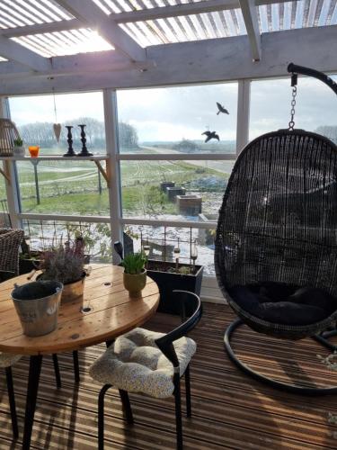a room with a table and chairs and a large window at Marsvinslund bed and breakfast in Viborg