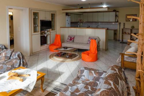 sala de estar con sillas de color naranja y sofá en Dimitri's Mountain House, en Karpenisi
