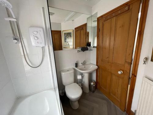 uma casa de banho com um WC, um lavatório e um chuveiro em Robinsons Cottage, central and quiet em Cockermouth