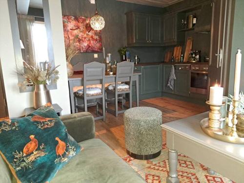 ein Wohnzimmer mit einem Sofa und eine Küche mit einem Tisch in der Unterkunft Nydelig utsikt, hotell-følelse in Beitostøl