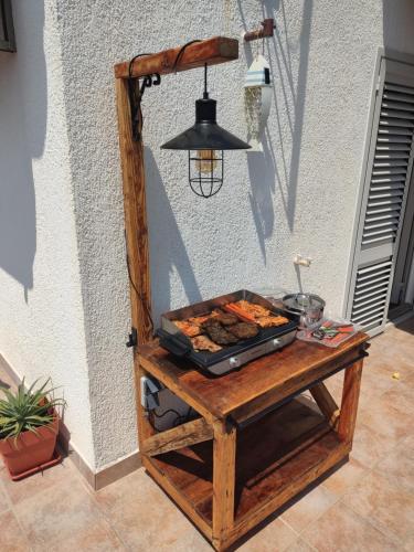 a table with a grill with food on it at Nikolina Rab Apartments in Rab