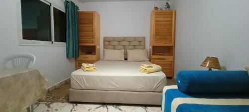 - une petite chambre avec un lit et un canapé dans l'établissement Studio pêcheur, à Oualidia