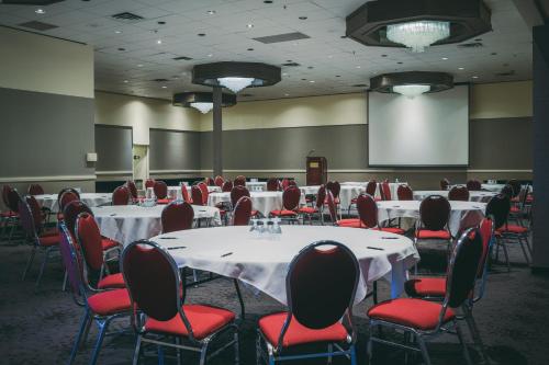 a conference room with tables and chairs and a screen at Hotel Blackfoot in Calgary