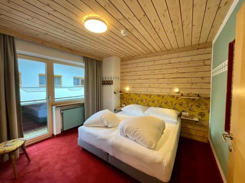 een slaapkamer met een groot bed met een houten plafond bij Apart Samnaun in Ischgl