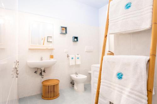 bagno bianco con lavandino e servizi igienici di MARCHE FULL EXPERIENCE-Apartments a Porto SantʼElpidio
