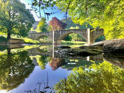 a bridge over a river in a park at The Great View in Bouillon