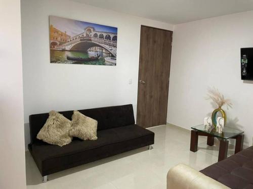 a living room with a black couch and a painting at Apartamento pitalito in Pitalito