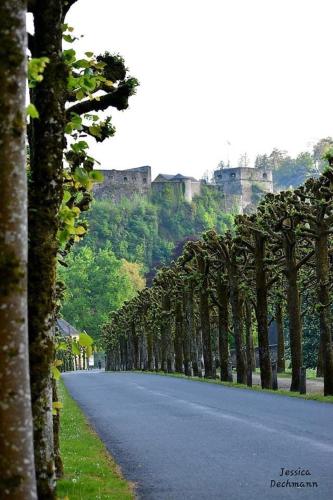 a tree lined road with a castle in the background at The Great View in Bouillon