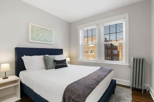 um quarto com uma cama grande e 2 janelas em Pleasant 2BR Apt with Furnished Kitchen - Troy 2 em Chicago