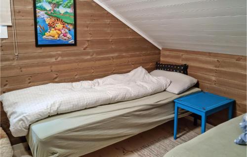 a small room with a bed and a blue table at 3 Bedroom Cozy Home In Vikes in Vikeså