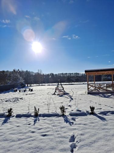 a field covered in snow with the sun in the sky at Stacja Miśków in Wilków Nowy