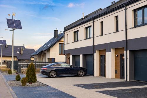 a black car parked in front of a building at Apartment LUXOR - Airport Katowice-Pyrzowice in Bobrowniki