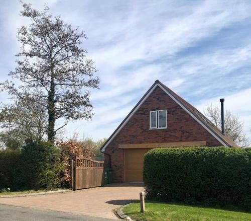 a brick house with a garage and a tree at Harrow Hayloft Rural 80m2 Village Hideaway Retreat in Himbleton