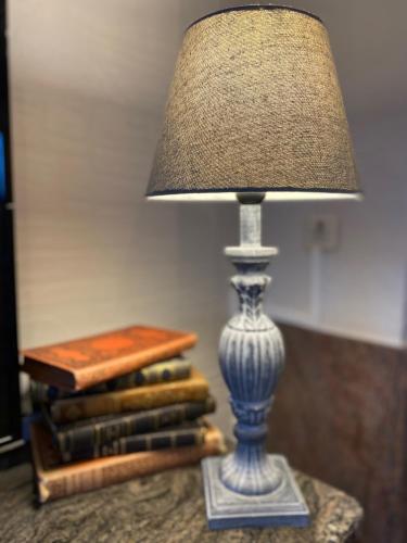 a lamp sitting on a table next to a stack of books at The Great View in Bouillon