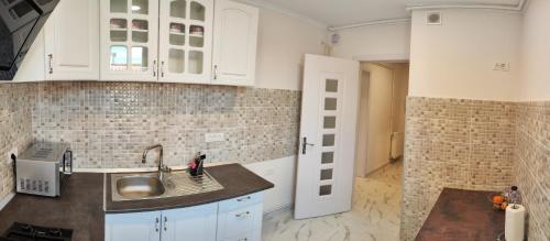 a kitchen with white cabinets and a sink at Timisoara Central in Timişoara