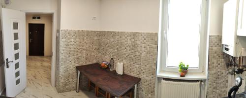 a bathroom with a wooden table and a brick wall at Timisoara Central in Timişoara