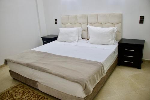 a bedroom with a large bed with white sheets and pillows at Magnifique Duplex à Marrakech in Marrakech