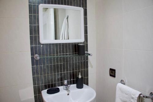 La salle de bains est pourvue d'un lavabo et d'un miroir. dans l'établissement Magnifique Duplex à Marrakech, à Marrakech