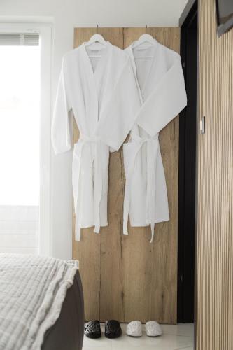 a bedroom with white clothes hanging on a wall at Holiday House Sunset Spa in Šentjernej