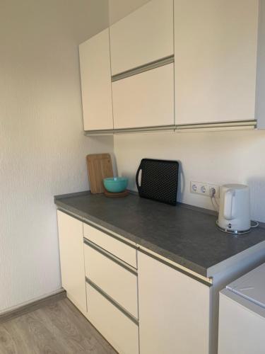a kitchen with white cabinets and a counter top at Apartament Blumenblick in Rielasingen-Worblingen