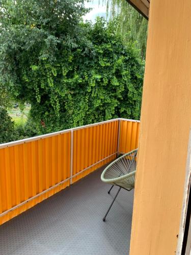 a chair on a balcony with an orange fence at Apartament Blumenblick in Rielasingen-Worblingen