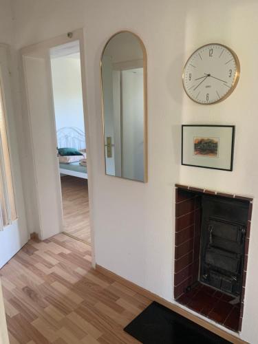 a room with a fireplace and a clock on the wall at Apartament Blumenblick in Rielasingen-Worblingen