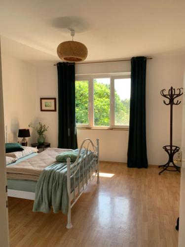 - une chambre avec un lit et une grande fenêtre dans l'établissement Apartament Blumenblick, à Rielasingen-Worblingen