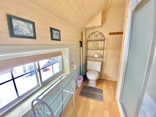 a small bathroom with a toilet and a window at 4 Bedroom Cottage on Manitoulin Island Next to Sand Beaches! in Providence Bay