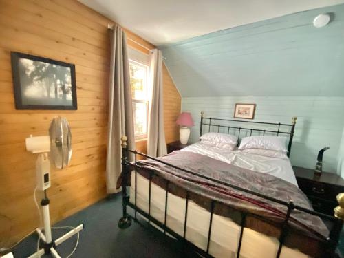a bedroom with a bed in a room with a window at 4 Bedroom Cottage on Manitoulin Island Next to Sand Beaches! in Providence Bay