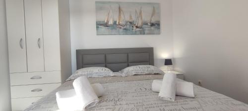 a white bedroom with a large bed with white pillows at Sunset Apartments in Slano