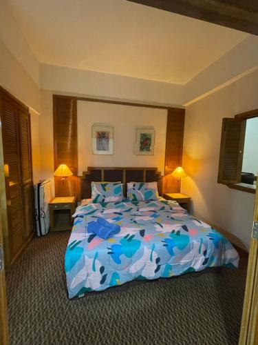 a bedroom with a bed with a blue comforter at Riviera Bay Resort Condominium in Kampong Lereh