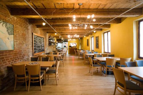 a dining room with tables and chairs and a brick wall at Pension Krajinská 27 in České Budějovice