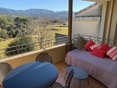 uma varanda com 2 camas, uma mesa e cadeiras em appartement cosy avec climatisation réversible GOLF DE SAUMANE em Saumane-de-Vaucluse