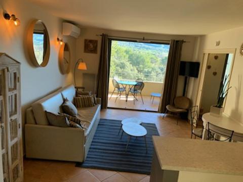 un soggiorno con divano e tavolo di appartement cosy avec climatisation réversible GOLF DE SAUMANE a Saumane-de-Vaucluse