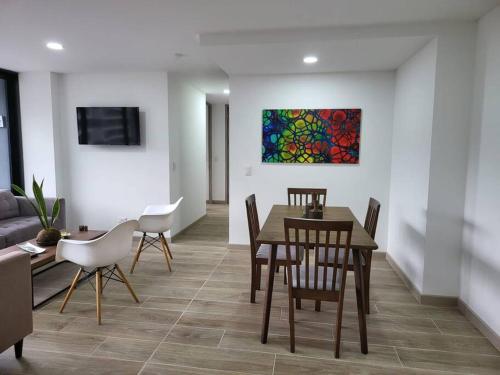 a dining room with a table and chairs and a painting at Entire Apartment in El Retiro in El Retiro