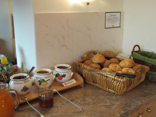 a counter with a basket of bread and cups of coffee at Haus Alpenglühn in Schladming