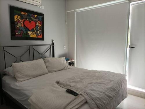 1 dormitorio con 1 cama con mando a distancia en Apartamento para vacaciones en Buenos Aires