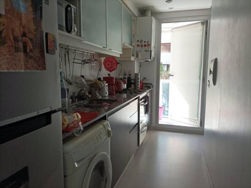 cocina con lavadora y ventana en Apartamento para vacaciones en Buenos Aires